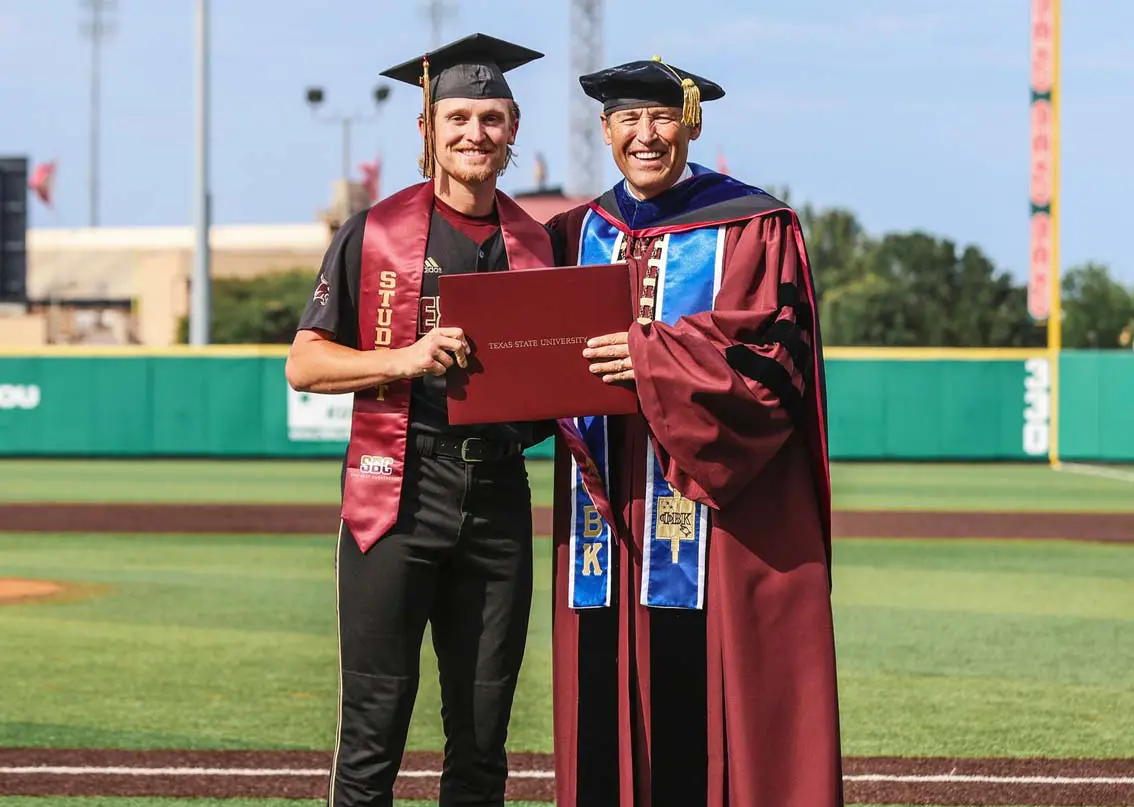 A younger and older man posing with diploma