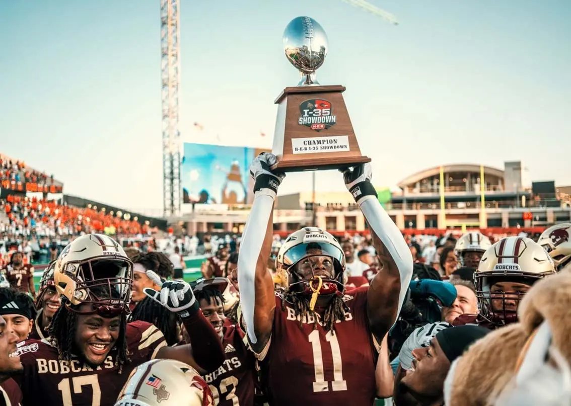 Football player holding up trophy